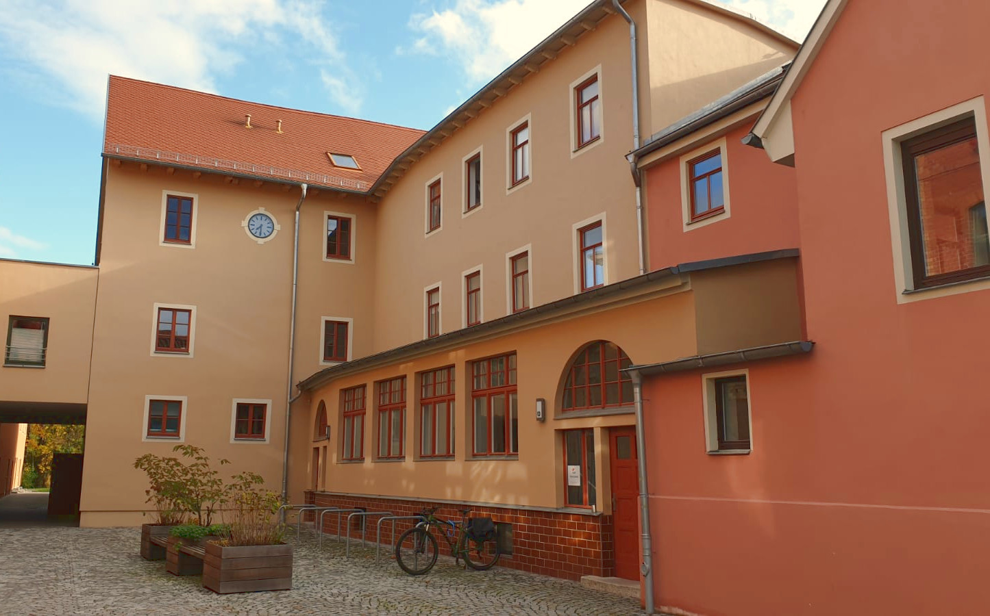 Ansicht Innenhof mit historischer Turmuhr, warme Farben